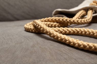 Kenevir fitili, sırt çantasının ya da sırt çantasının yakın plan fotoğraflı gri bir kanepenin üzerinde görüntüsü.