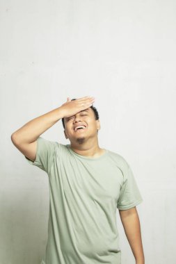 Alnında gözlük olan Asyalı bir adam beyaz arka planda sersemlemiş hissediyor.