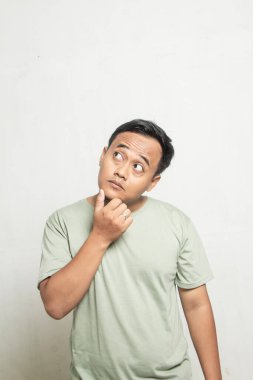 Komik görünüşlü bir adam, beyaz adaçayı rengi bir gömlek giyiyor..