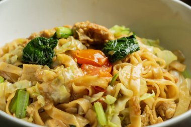  Seçilmiş Tayland eriştesinin yumurta ve sosis kombinasyonlu hali, Kwetiau 'nun beyaz kaseli Asya yemeği.