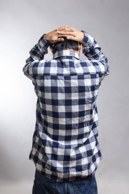 Stres jesti yaparken kafasını tutan bir adamın dikiz aynasından bakıldığında, adam beyaz, işaretli bir gömlek giyiyor.