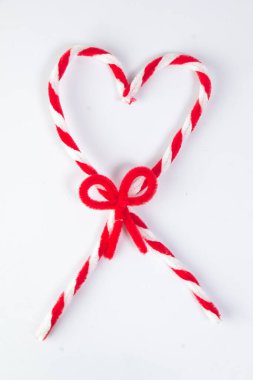 Kalp şeklinde lolipop aksesuarları, kırmızı ve beyaz boru temizleyicileri beyaz üzerine izole edilmiş kravatlar.