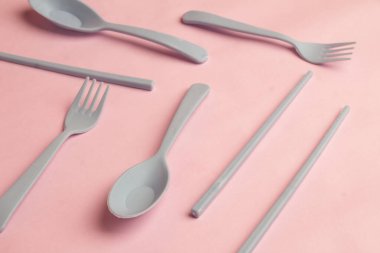 Çatal, kaşık, çubuk, gri plastikten yapılmış Pembe Arkaplan gibi çatal bıçakların arka planı