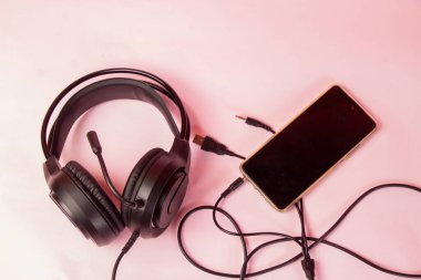 Kulaklıklar, Mikrofon ve Pembe Yüzeyde Akıllı Telefon