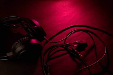 Koyu kırmızı yüzeydeki kulaklıklar