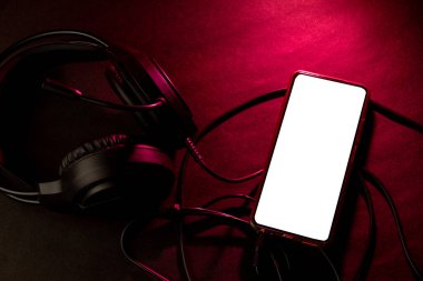 Kırmızı ışıklandırmalı kulaklık ve akıllı telefon.