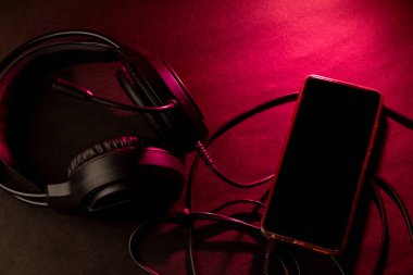 Kırmızı Aydınlık Yüzeyinde Kulaklık ve Akıllı Telefon