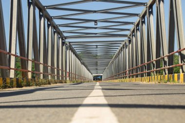 Vintage Steel Köprüsü 'nün koridorunda asfalt yol. Açık Mavi Gök Yapısı.