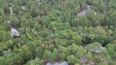 Ormanın yakınındaki yeşil ağaçların arasına park edilmiş kamaraların ve arabaların üst görüntüsü. Broken Bow, Oklahoma, ABD 'deki ormandaki kır evleri.