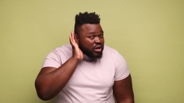 Африкансько Американський Чоловік Рожевій Футболці Тримає Руку Біля Вуха Намагаючись — стокове відео
