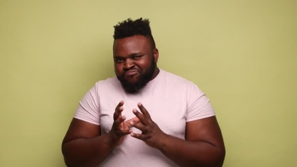 Αφροαμερικάνος Που Φοράει Ροζ Μπλουζάκι Σφίγγει Χέρια Και Σχεδιάζει Σατανικές — Αρχείο Βίντεο