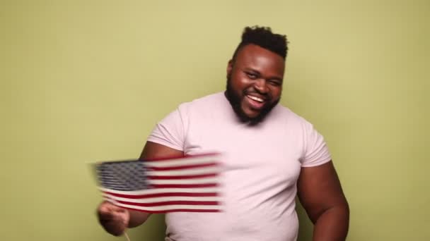 Afrikansk Amerikansk Mand Iført Lyserød Shirt Holder Flag Ser Kameraet – Stock-video