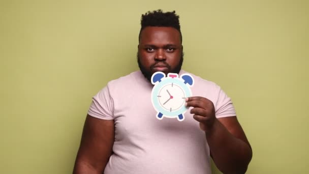 Hombre Afroamericano Serio Con Una Camiseta Rosa Con Despertador Papel — Vídeos de Stock