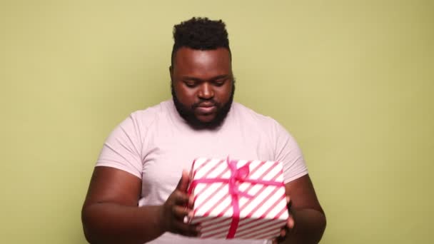 Homem Afro Americano Curioso Vestindo Caixa Presente Listrada Rosa Shirt — Vídeo de Stock