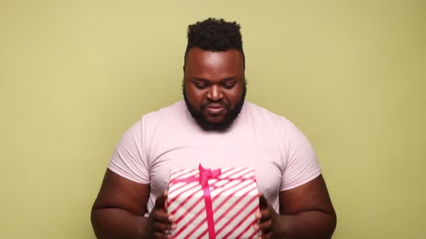 티셔츠를 상자를 선물하고 카메라를 축하하는 아프리카 미국인 스튜디오는 배경에 — 비디오