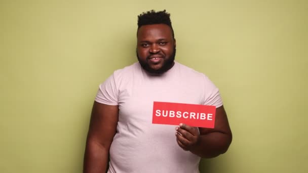Glücklich Positiver Optimistischer Afroamerikanischer Mann Rosa Shirt Trägerkarte Mit Abonnement — Stockvideo