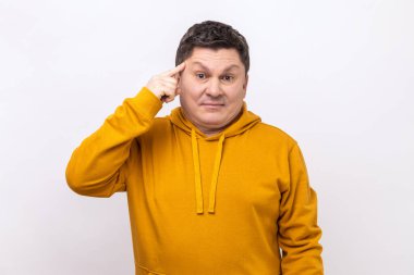 Portrait of man showing stupid gesture, looking at camera with condemnation and blaming for insane plan, dumb suggestion, wearing urban style hoodie. Indoor studio shot isolated on white background.