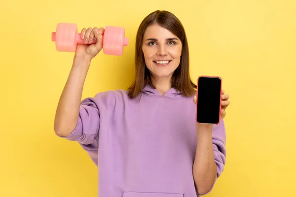 Feliz Mulher Positiva Segurando Smartphone Tela Vazia Halteres Rosa Anunciando — Fotografia de Stock