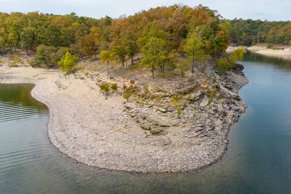 Aerial view of landscape of the rocky coast of Broken Bow lake, Oklahoma, USA. Autumn scenery of coastal line with forest on the bank.