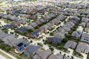 İnsansız hava aracı, yazları açık havada bir sürü evi ve yeşil ağaçları olan caddeleri görüyor..