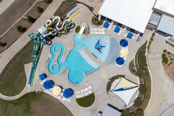 stock image Aerial view from flying drone of aquapark, water park with various water slides, pool, sun loungers and green area.