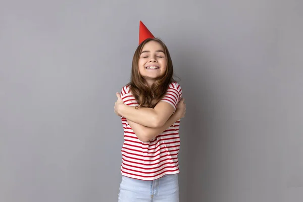 Menina Vestindo Camiseta Listrada Cone Festa Abraçando Com Expressão Prazer — Fotografia de Stock