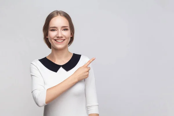 Portrét Pěkně Usměvavé Optimistické Ženy Bílých Šatech Ukazující Prstem Reklamní — Stock fotografie
