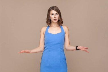 Bunu nasıl yaparsın? Dalgalı saçlı kızgın bir kadın avuçlarını açar, kameraya kızgın bir şekilde bakar, mavi elbiseli biriyle kavga eder. Açık kahverengi arka planda kapalı stüdyo çekimleri.