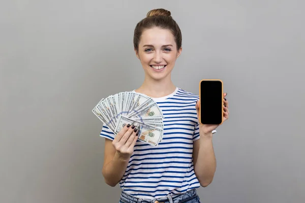 티셔츠를 스크린 달러화 지폐를 스마트폰을 여성의 은회색 배경에 고립되어 있었다 — 스톡 사진