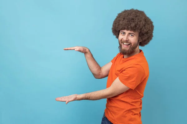 Portrait Positive Optimistic Man Afro Hairstyle Presenting Area Advertisement Looking — Stock Photo, Image