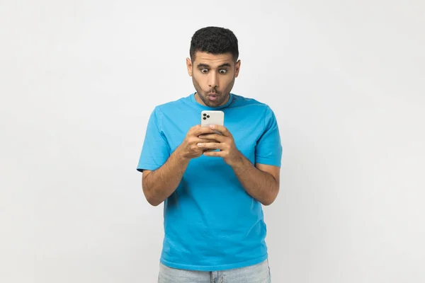 Portrét Šokovaného Neoholeného Muže Modrém Tričku Stojícího Mobilním Telefonem Kontrolujícího — Stock fotografie