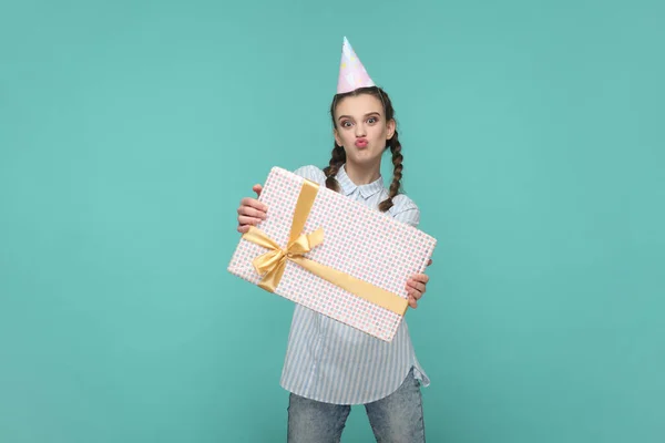줄무늬 셔츠와 상자에 포장된 카메라를 바라보는 긍정적 소녀의 모습이다 스튜디오 — 스톡 사진