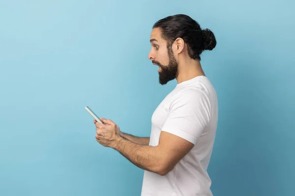 Sakallı Beyaz Tişörtlü Cep Telefonu Kullanırken Şok Gösteren Interneti Arayan — Stok fotoğraf