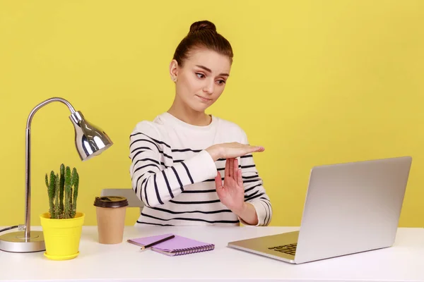 疲れた女性マネージャーは ノートパソコンの画面を見ている時間ジェスチャーを表示し ビデオ通話で話して 一時停止を求めて オンライン通信の休憩 黄色の背景に隔離された屋内スタジオショット — ストック写真