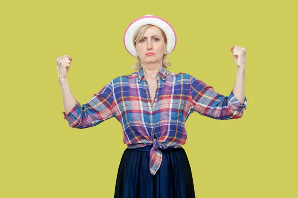 Портрет Зрелой Женщины Клетчатой Рубашке Шляпе Поднимает Руки Показывает Мускулы — стоковое фото