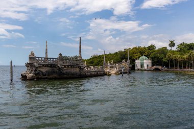 Miami, Florida - 25 Ağustos 2023 Biscayne Körfezi 'nde taştan dalgalı su mavnası ve Muhteşem Vizcaya Konağı.