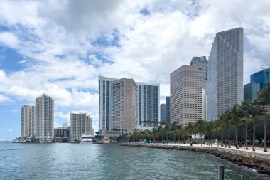Miami, Florida - 25 Ağustos 2023: Büyük tropikal bitki örtüsü, modern evler ve kuleler, ticari alanlar, su, yaz havası, mavi gökyüzü.