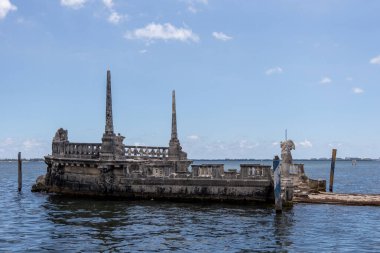 Miami, Florida - 25 Ağustos 2023 Biscayne Körfezi 'nde taştan dalgalı su mavnası ve Muhteşem Vizcaya Konağı.