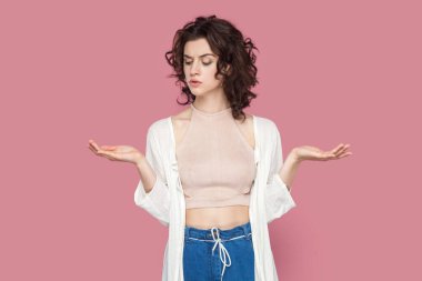 Dalgın, kıvırcık saçlı, günlük kıyafet giyen, avuç içlerini açıp fotokopi çeken, karar veren şüpheli bir kadının portresi. Pembe arka planda kapalı stüdyo çekimleri.