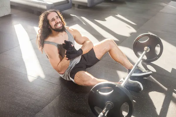Spor Salonunda Uzun Kıvırcık Saçlı Bir Adamın Portresi Yerde Oturup — Stok fotoğraf