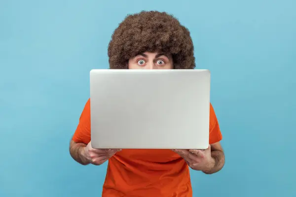 Afro Saçlı Turuncu Tişörtlü Yüzünün Yarısını Dizüstü Bilgisayarla Kaplayan Büyük — Stok fotoğraf