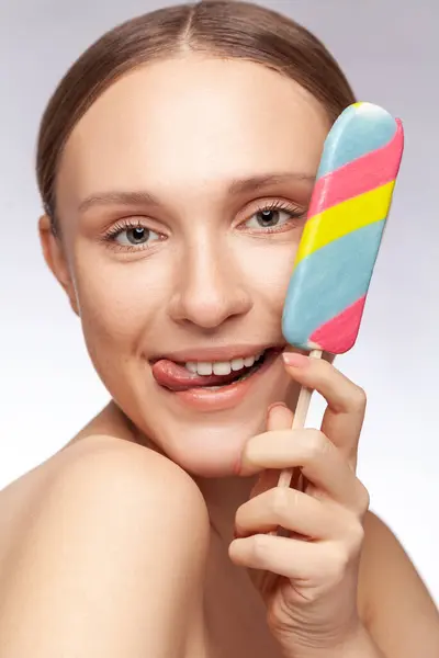 보여주는 맛있는 아이스크림을 어깨와 즐거운 여자의 클로즈업 초상화 배경에 스튜디오 로열티 프리 스톡 이미지