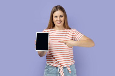 Tableti boş bir ekranla gösteren sarışın kadın portresi ilanınız için model ekran elektronik aletli kadın. Mor arka planda izole edilmiş kapalı stüdyo çekimi.
