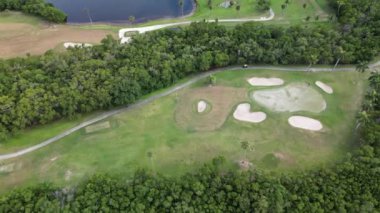 Çimenli tarlaları ve ağaçları olan canlı bir parkın insansız hava aracı çekimi, sakin bir açık hava kaçışı ve gün ışığında dinlenmek için güzel bir manzara.