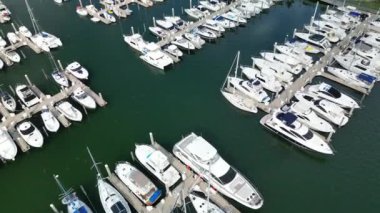 Yaz güneşinin altında, okyanus suyuna karşı kıyıda demirlemiş yatların hava manzarası.