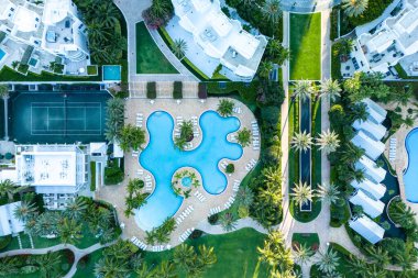 Palmiye ağaçlarıyla çevrili büyük yüzme havuzlu, lüks tropikal tatil beldesi, güzel mimari ve dinlendirici açık hava alanı, Playa Miami Plajı.