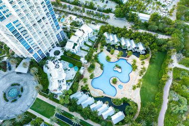 Havuzu, palmiyeli yolları ve sakin tropikal tatil kaçamakları için boş alanları olan muhteşem otellerin havadan görünüşü, Playa Miami Plajı