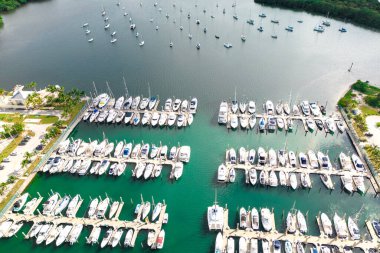 Drone view of harbor with numerous yachts and boats along the dock on sunny summer day clipart