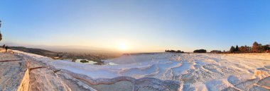 Türkiye 'nin Pamukkale kentindeki sıcak mineral kaynaklarının oluşturduğu beyaz limon çağlayanı teraslarının panoramik manzarası