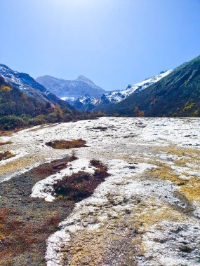 Huanglongvalley is made up of colorful lakes snow capped peaks green forest and glaciers  clipart